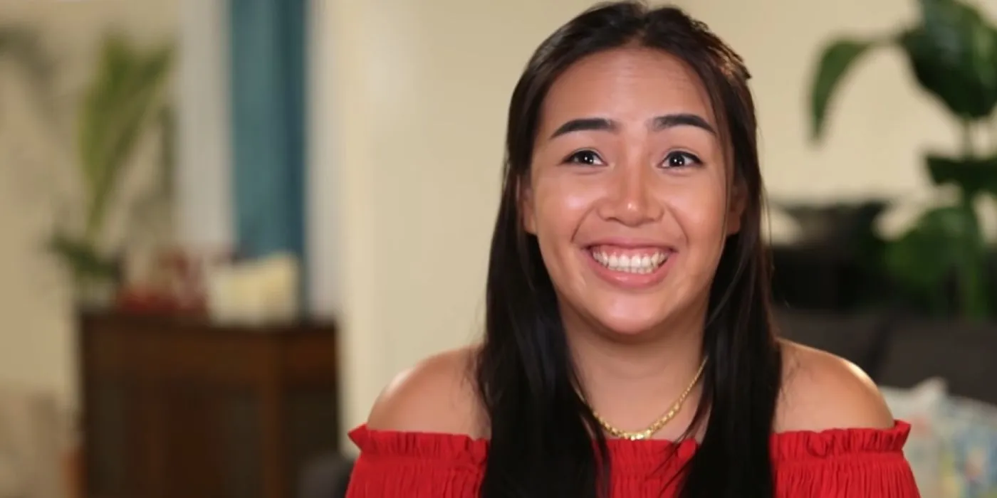 Annie Suwan in 90 Day Fiancé smiling in red off-shoulder dress