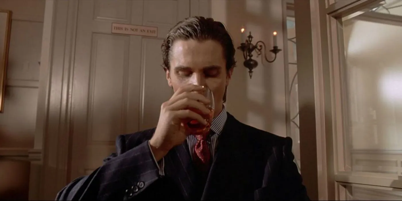 Christian Bale jako Patrick Bateman pijący whisky w American Psycho