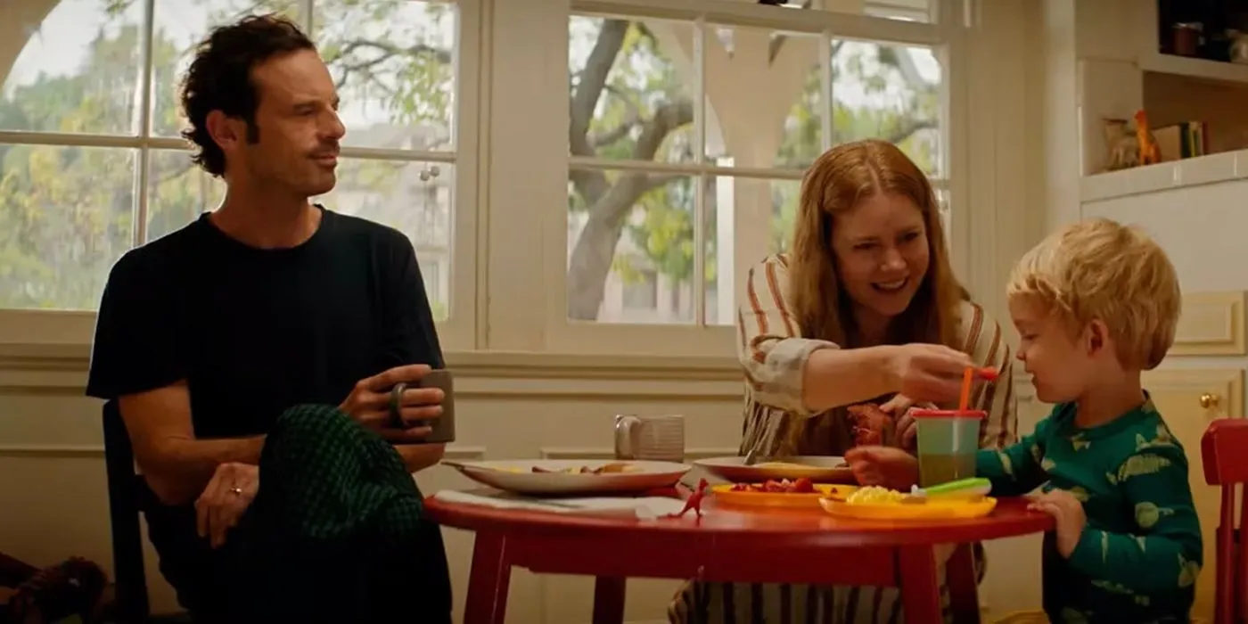 Amy Adams y Scoot McNairy con su bebé en la mesa de la cocina en Nightbitch