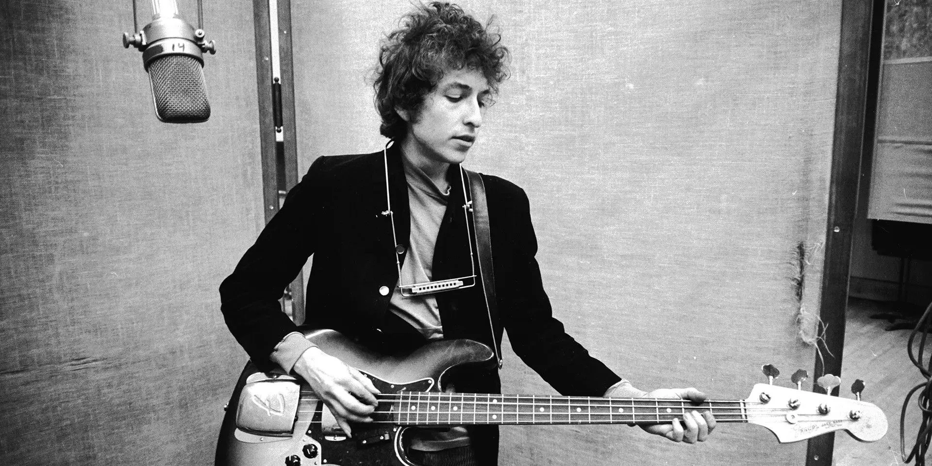 Bob Dylan playing the guitar in a recording studio