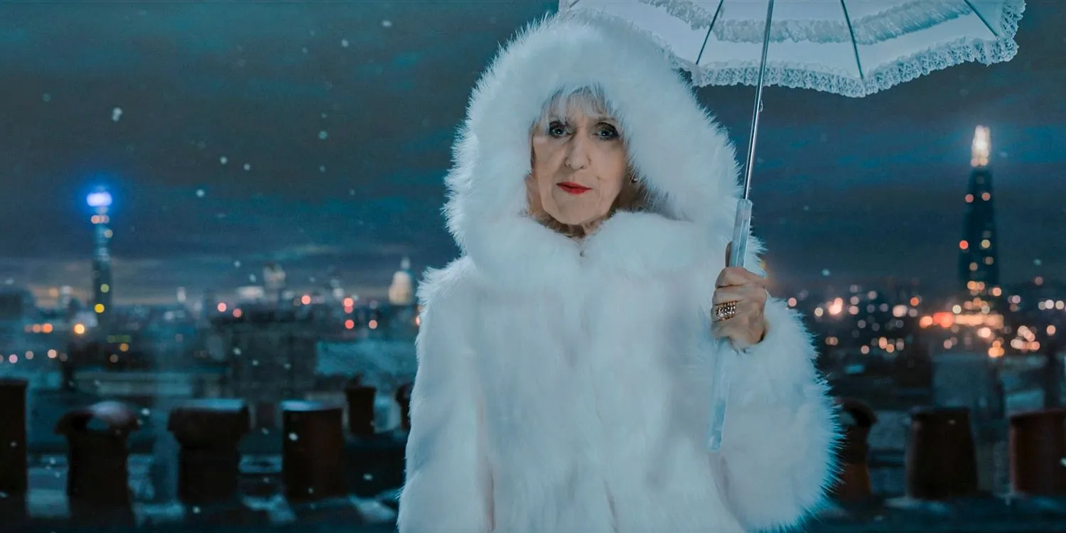 In „Doctor Who“ ist Mrs. Flood (Anita Dobson) während einer verschneiten Nacht stilvoll gekleidet und trägt einen Regenschirm.