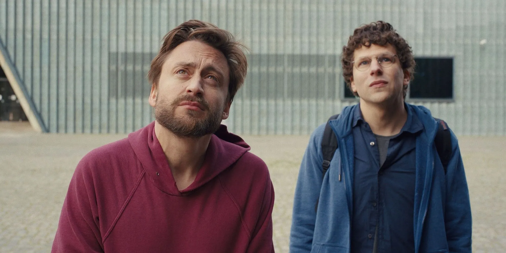 Kieran Culkin et Jesse Eisenberg regardent une statue en Pologne dans A Real Pain