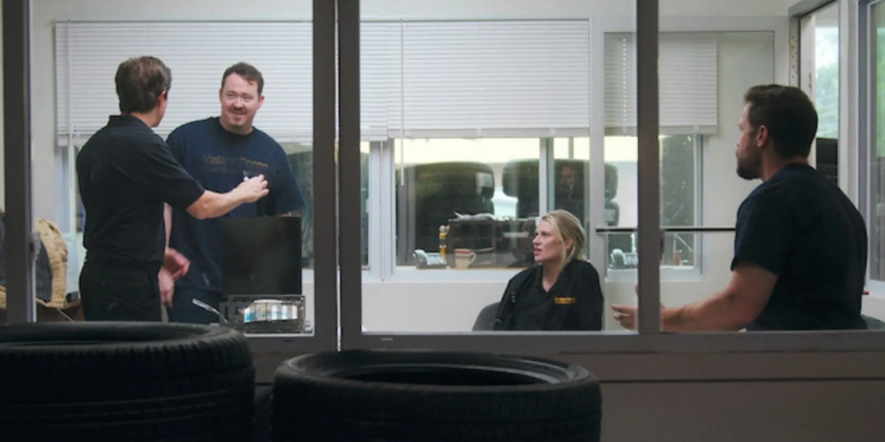 Das Team von Valley Forge Auto bespricht Strategie in einem Meeting, gesehen durch das Schaufenster in Tires