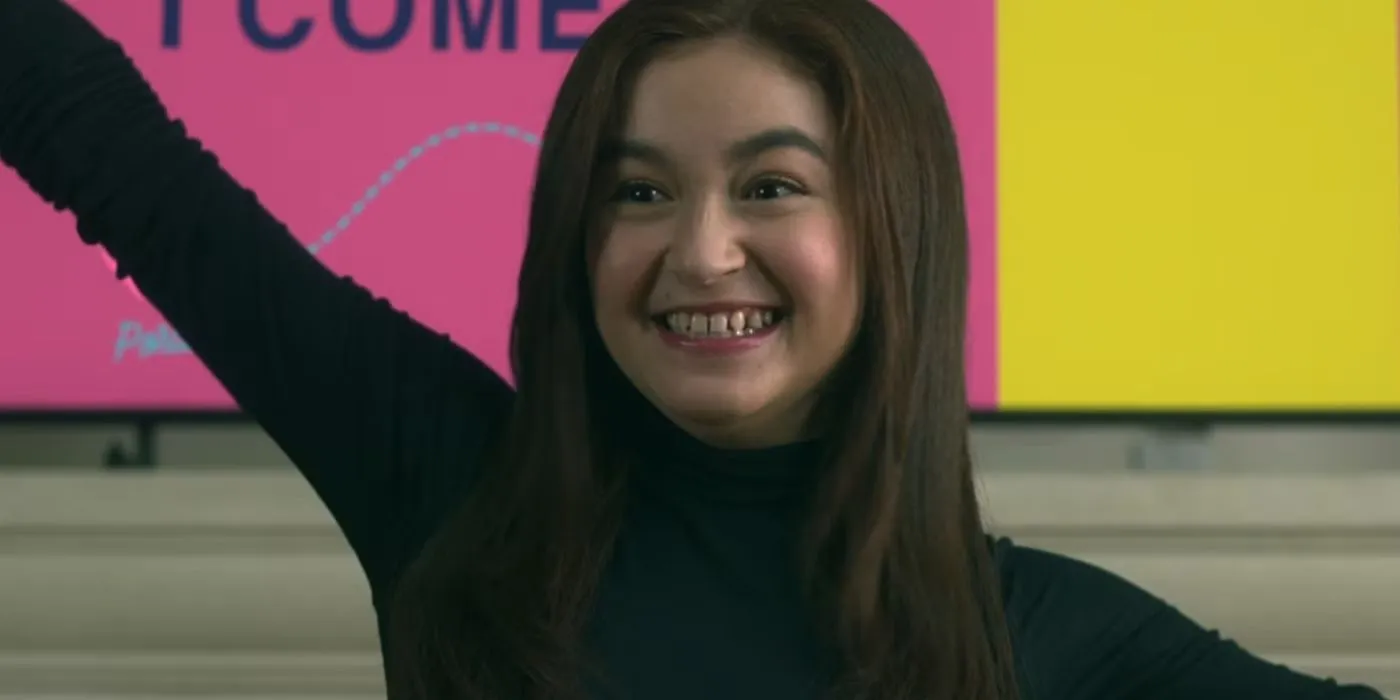 Anna Cathcart in XO, Kitty raising her hand and smiling Anna Cathcart in XO, Kitty raising her hand and smiling
