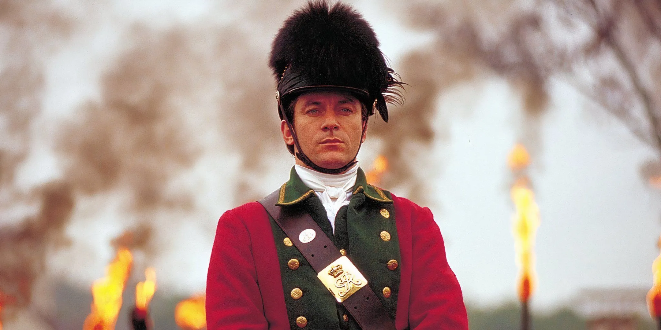 Jason Isaacs in front of burning torches as Col. William Tavington in The Patriot