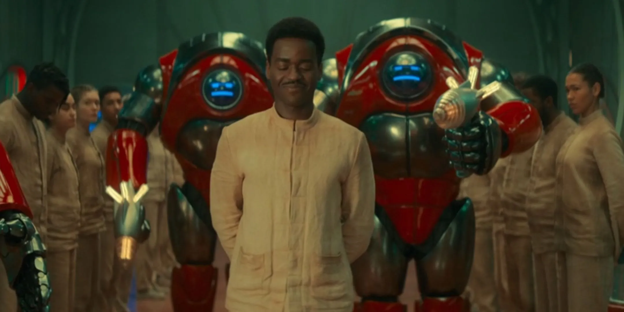 The Fifteenth Doctor smiling in Doctor Who with Robots behind him The Fifteenth Doctor smiling in Doctor Who with Robots behind him