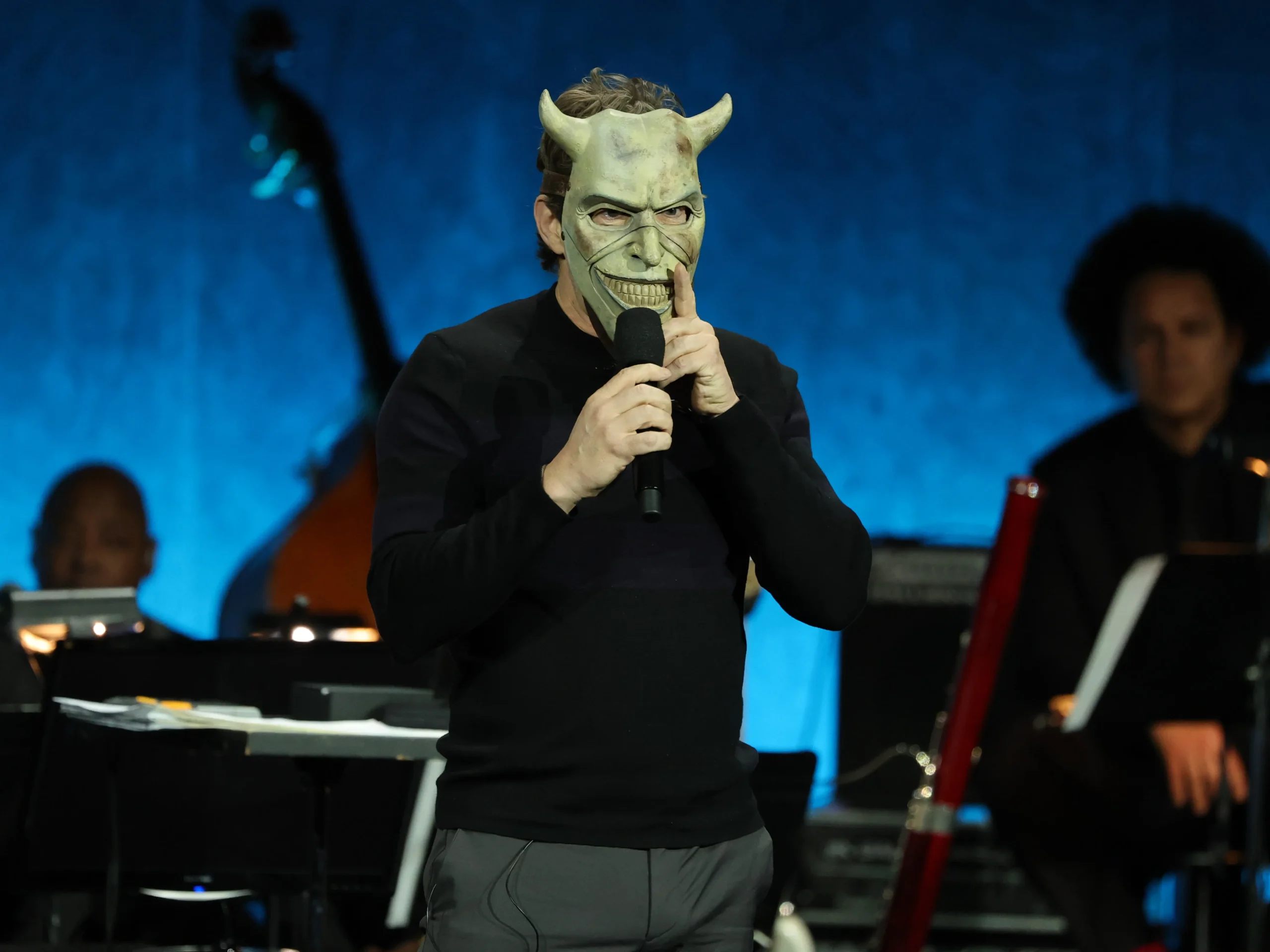 Jason Blum on stage wearing a Grabber mask