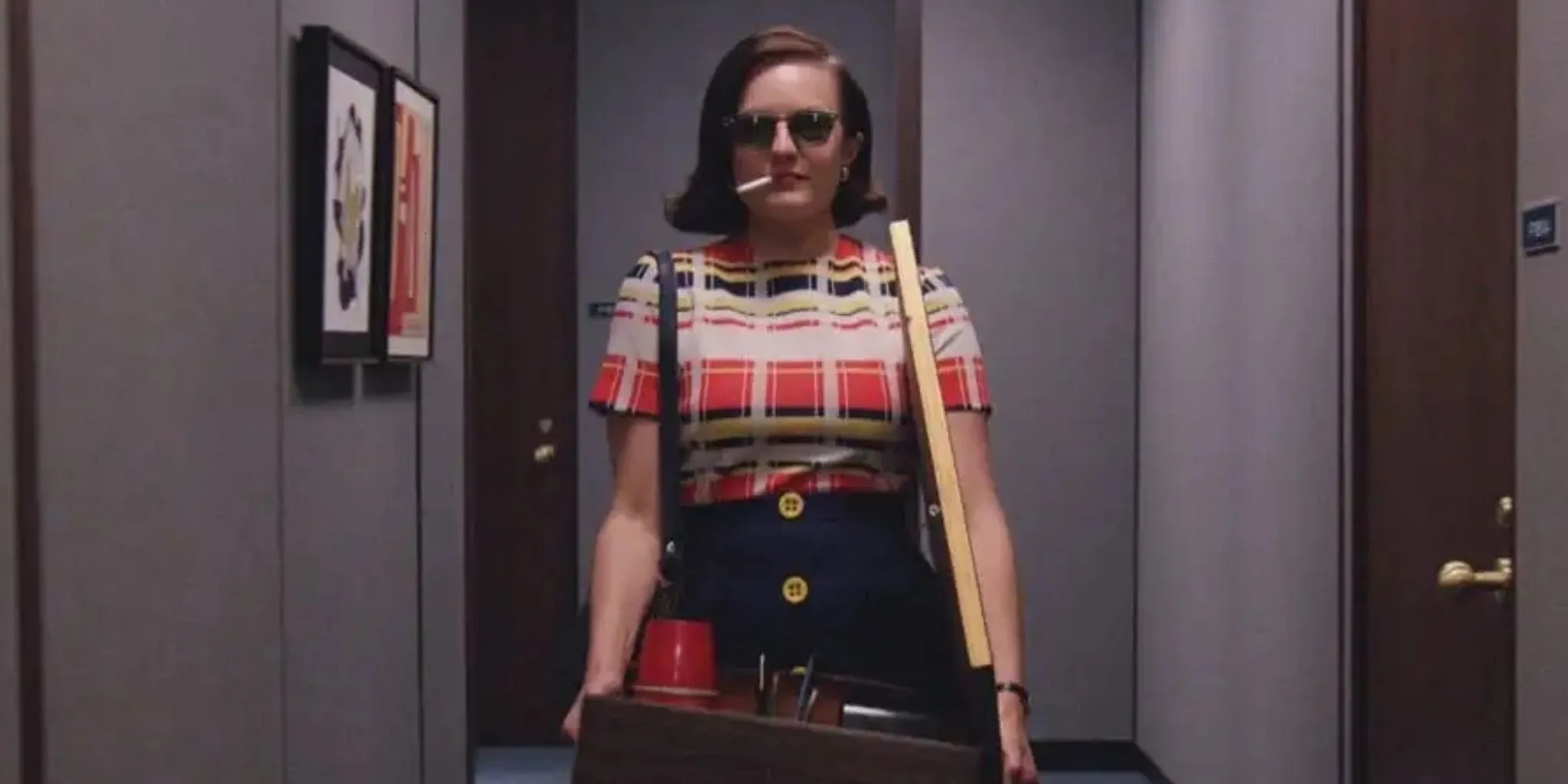 Peggy Olson (Elizabeth Moss) walking down the hallway with a box, sunglasses and a cigarette on Mad Men