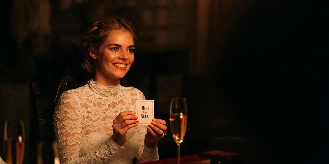 Grace holds up a card that says Hide and Seek in Ready or Not Grace holds up a card that says Hide and Seek in Ready or Not