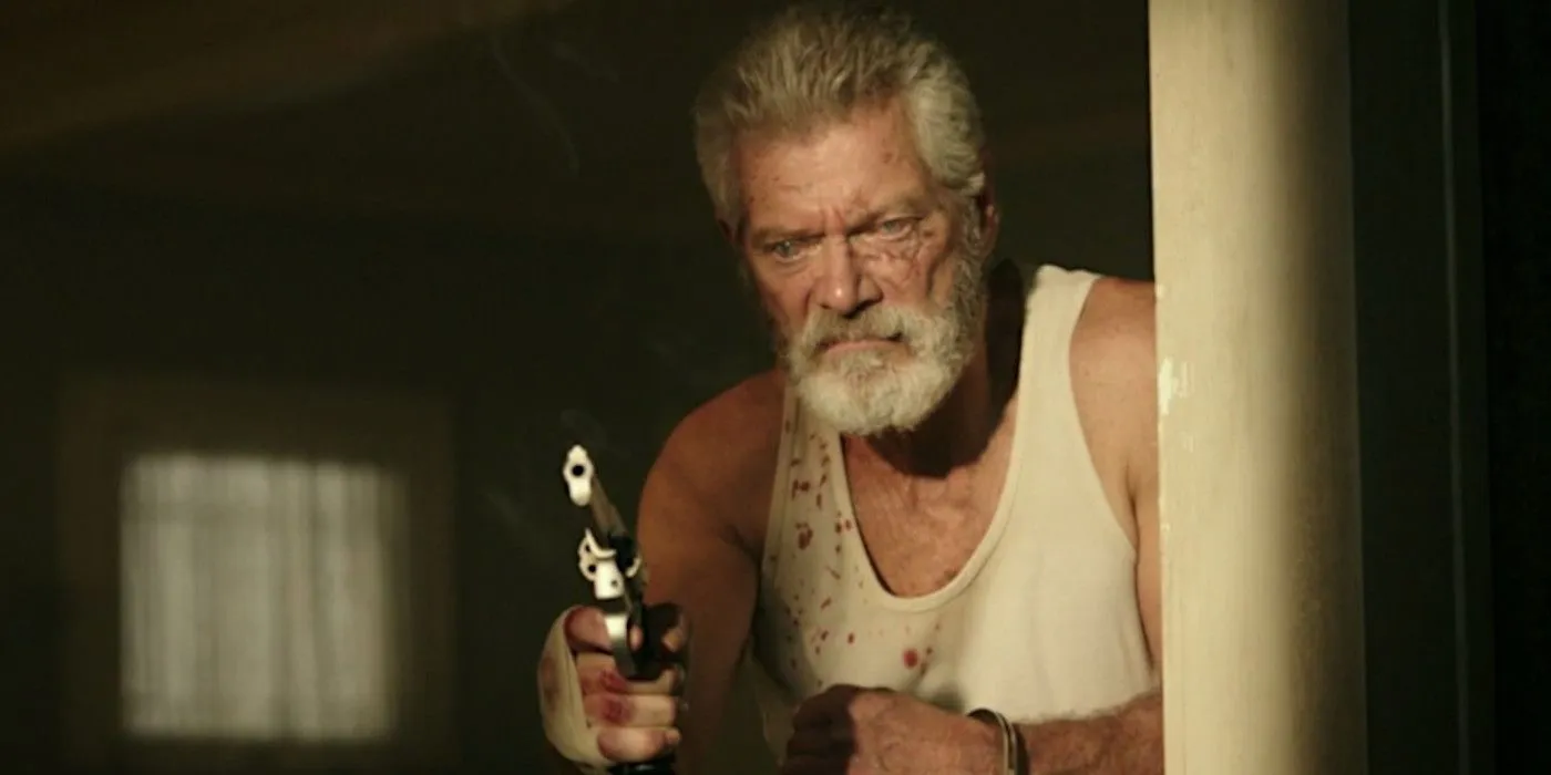 Stephen Lang as the Blind Man holding a gun