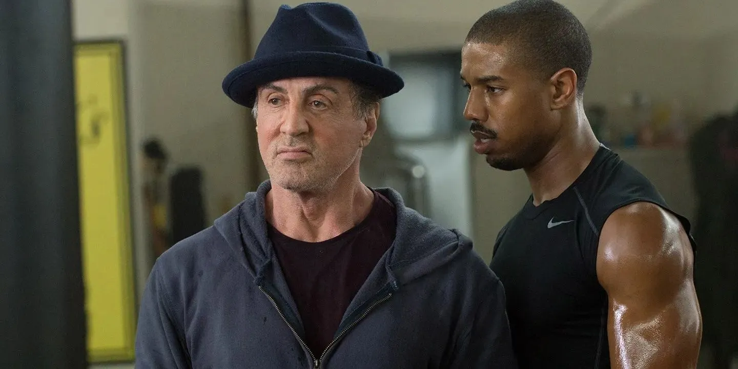 Adonis talks closely to Rocky as they look on in the gym in Creed