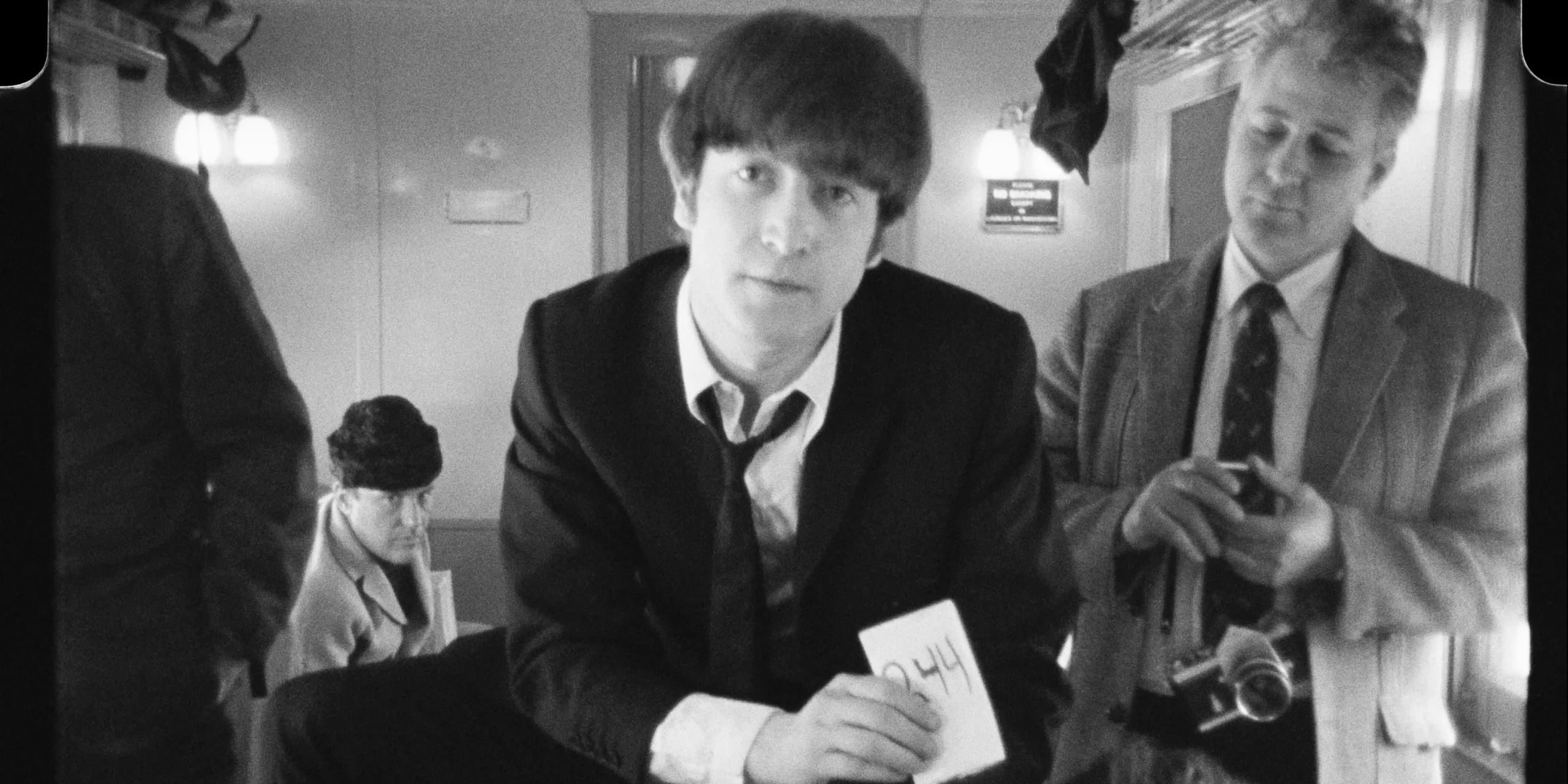 John Lennon holding a card