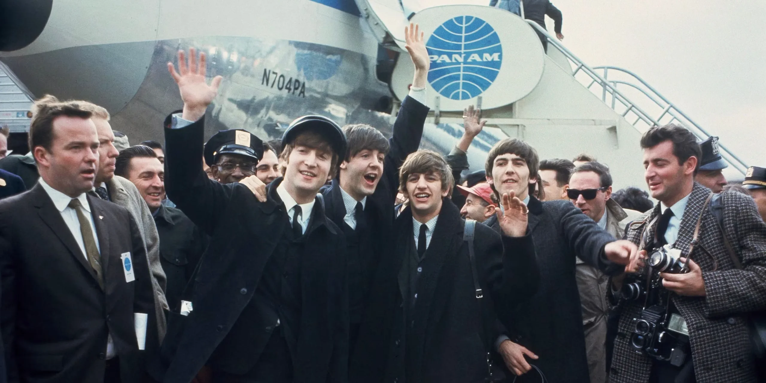 The Beatles waving to fans