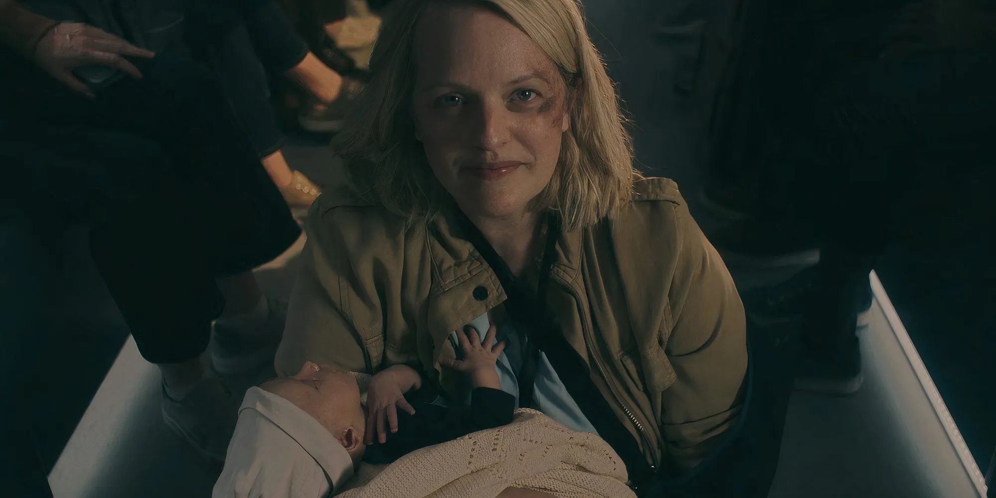June (Elisabeth Moss) smiling and holding a baby in The Handmaid's Tale