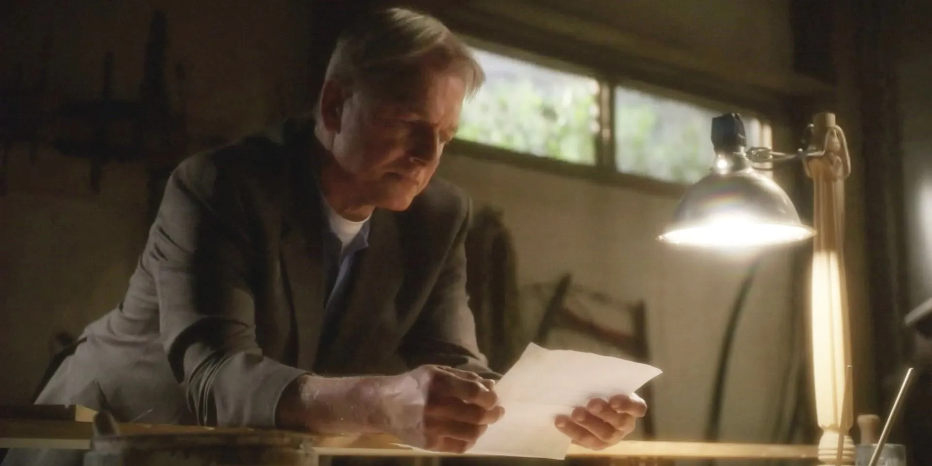 Mark Harmon as Gibbs staring thoughtfully at a paper in NCIS