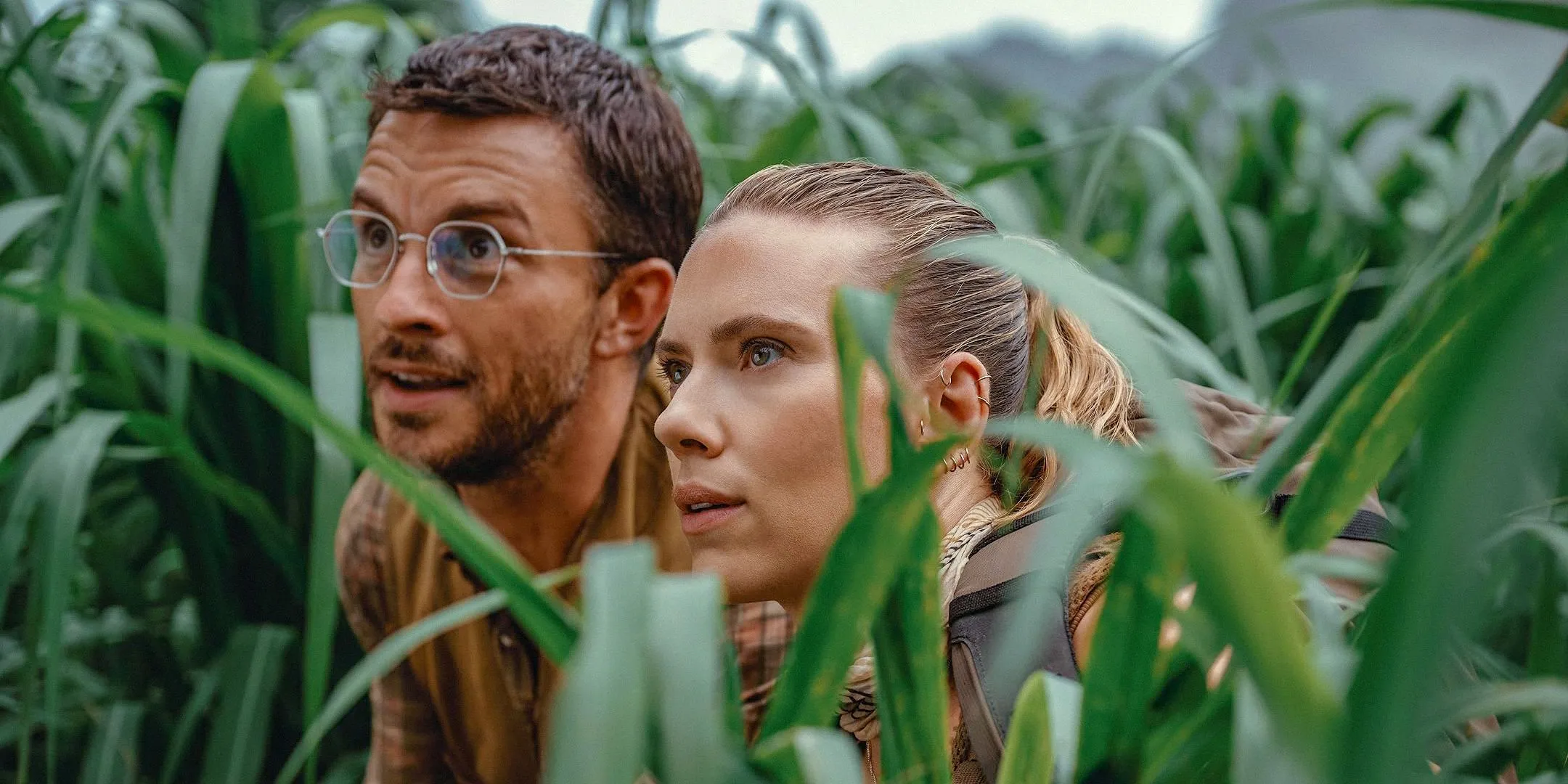 Characters observing the paradise-like setting in Jurassic World: Rebirth Characters observing the paradise-like setting in Jurassic World: Rebirth