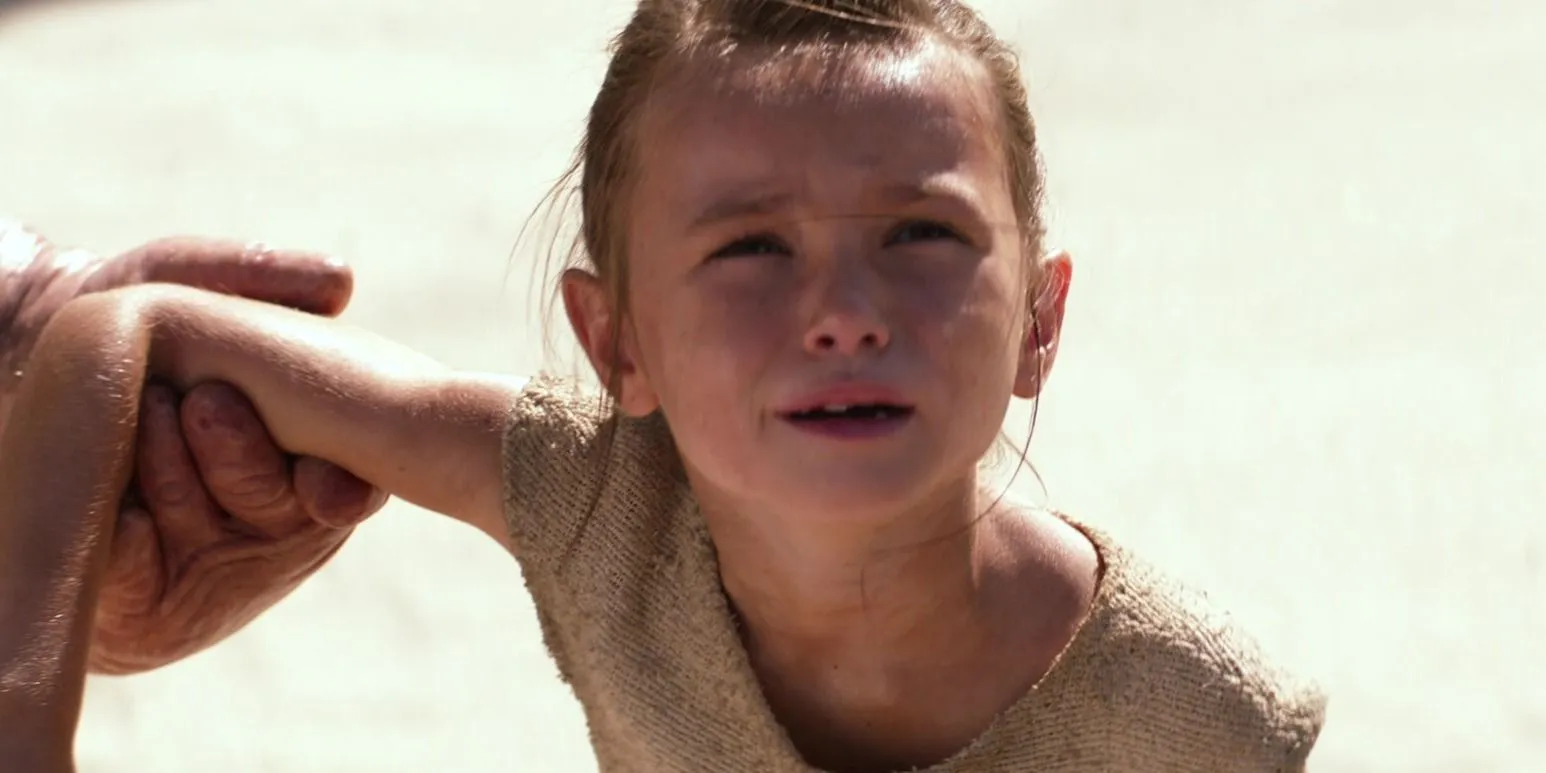 Young Rey distressed as Unkar Plutt holds her arm