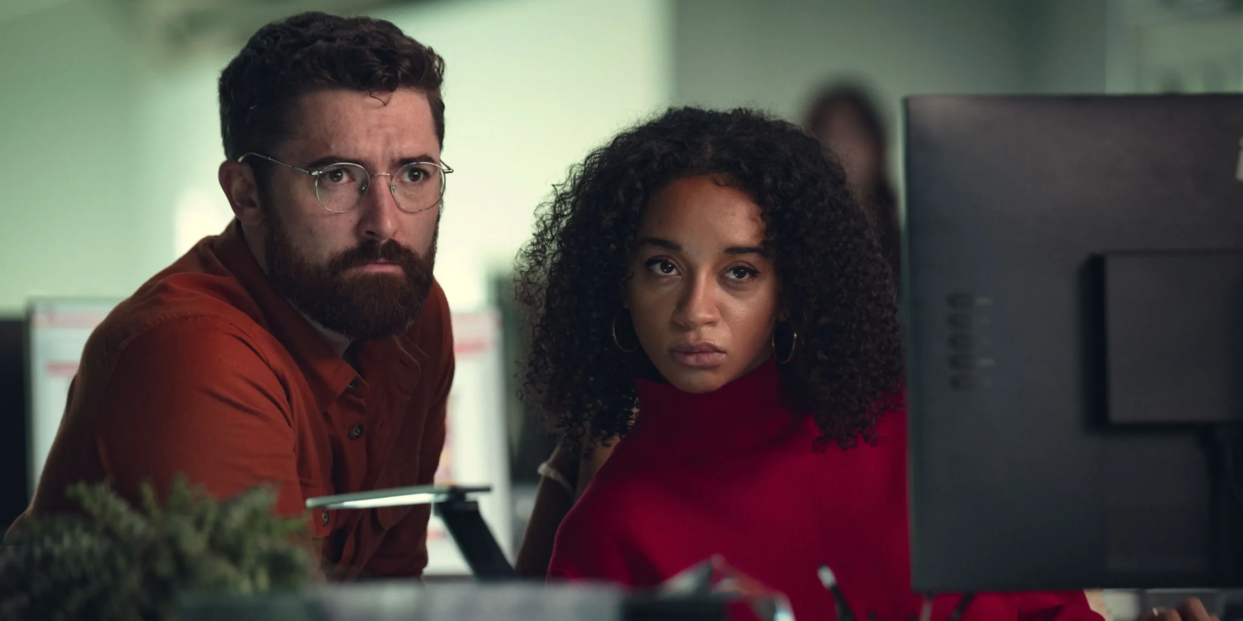 Maria and a colleague looking suspiciously past the camera in Black Mirror season 7, episode 2
