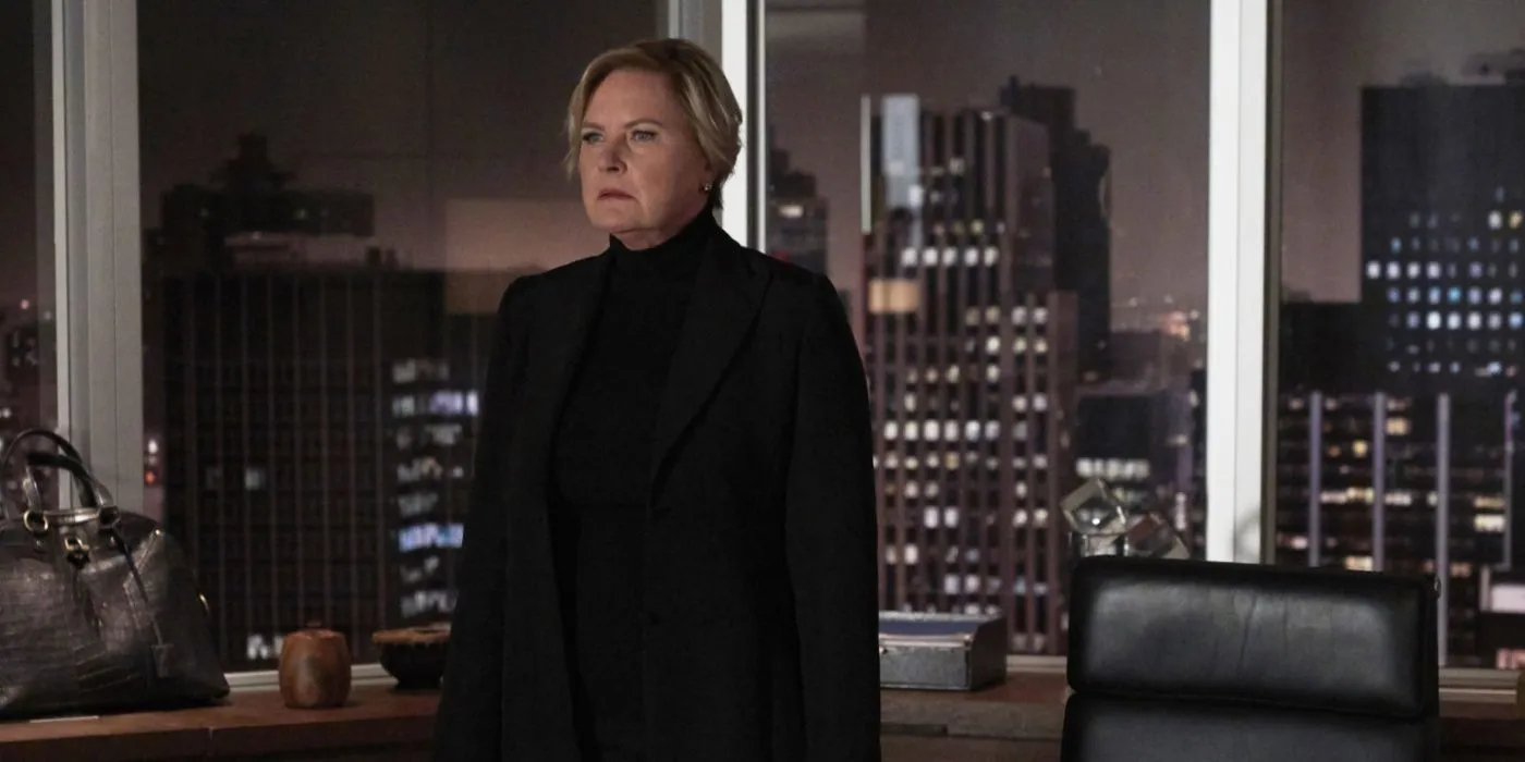 Faye(Denise Crosby)는 Suits에서 도시 스카이라인 앞에 서 있습니다.