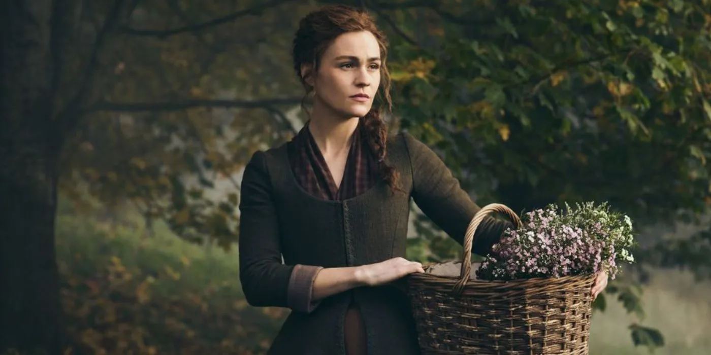 Sophie Skelton como Brianna Randall Fraser Mackenzie segurando uma cesta em Outlander Sophie Skelton como Brianna Randall Fraser Mackenzie segurando uma cesta em Outlander