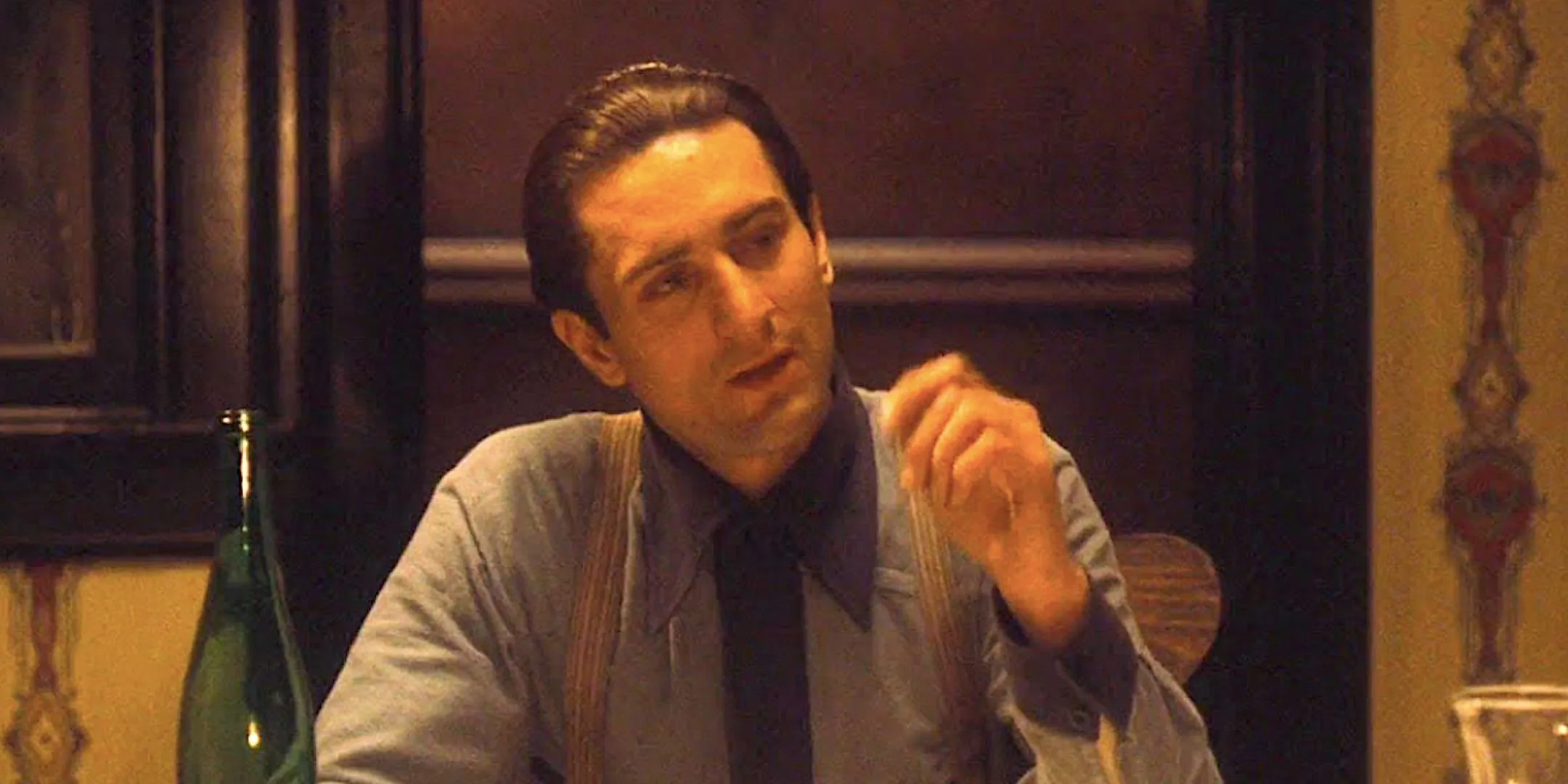 Robert De Niro's Vito Corleone sits at a dinner table in The Godfather Part II. Robert De Niro's Vito Corleone sits at a dinner table in The Godfather Part II.