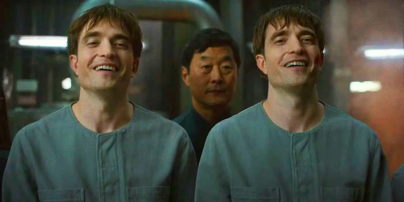 Robert Pattinson as Mickey 17 and 18 smiling in Mickey 17 Robert Pattinson as Mickey 17 and 18 smiling in Mickey 17