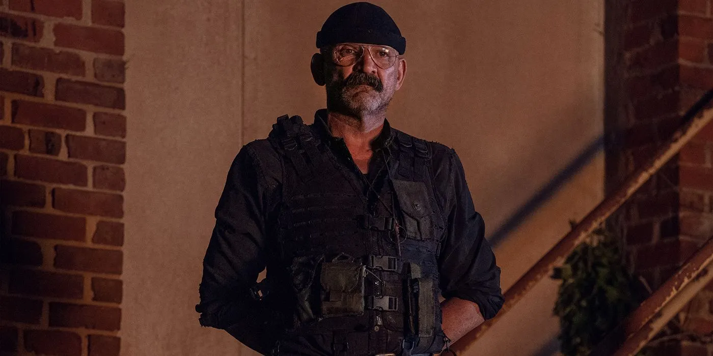 Pope from The Walking Dead standing with a military vest, his arms behind his back. Pope from The Walking Dead standing with a military vest, his arms behind his back.