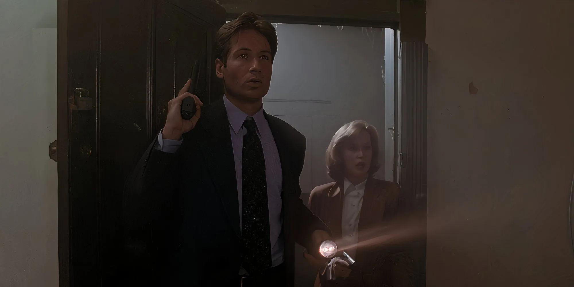 Mulder and Scully entering a house in The X-Files Mulder and Scully entering a house in The X-Files