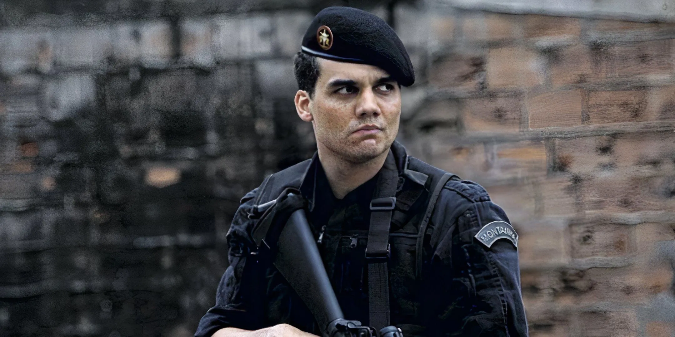 Wagner Moura holds a weapon in his hand and looks over to the side with a serious expression. Wagner Moura holds a weapon in his hand and looks over to the side with a serious expression.