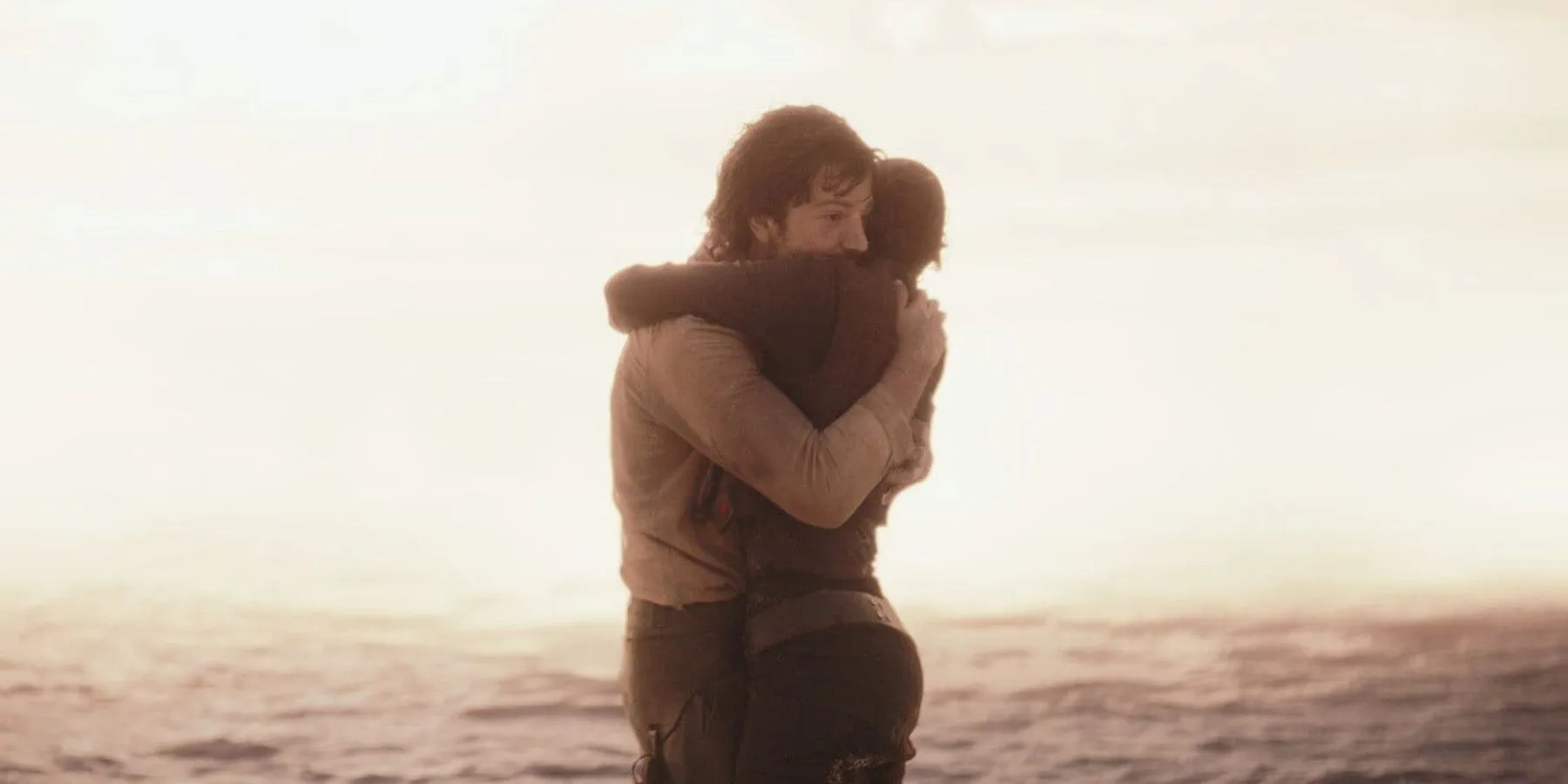 Cassian Andor and Jyn Erso embrace on Scarif