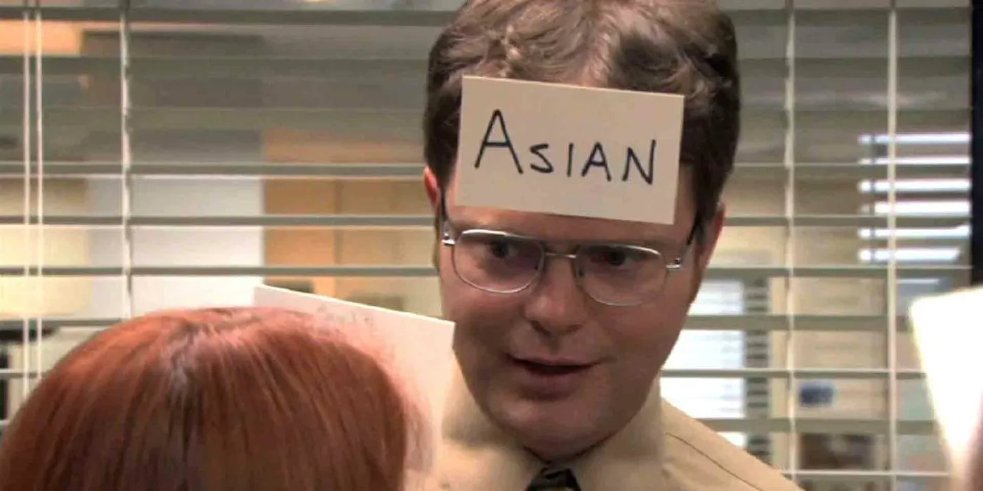 Dwight (Rainn Wilson) wearing a card on his forehead that says 