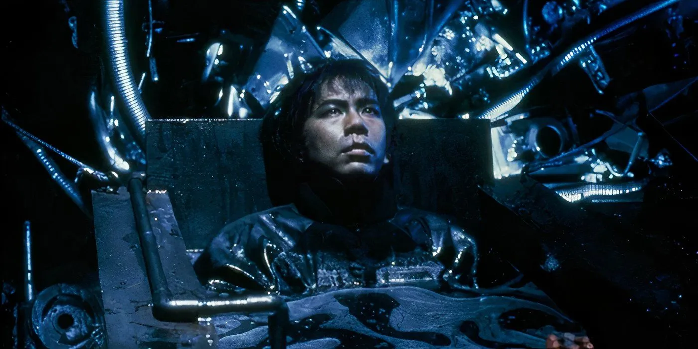A man is submerged in a pool of dark liquid in Tetsuo II: Body Hammer A man is submerged in a pool of dark liquid in Tetsuo II: Body Hammer
